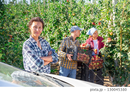 Woman standing beside car Woman standing beside car 130045380