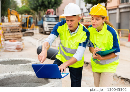 Two builders planning their work in construction plant 130045502