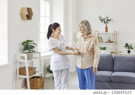 Senior people care, young kind nurse, geriatric medicine caretaker helping old woman, nursing home 130045525