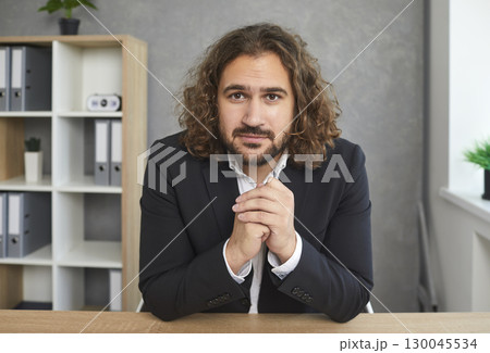 Online conference call portrait of young businessman looking at camera and listening 130045534
