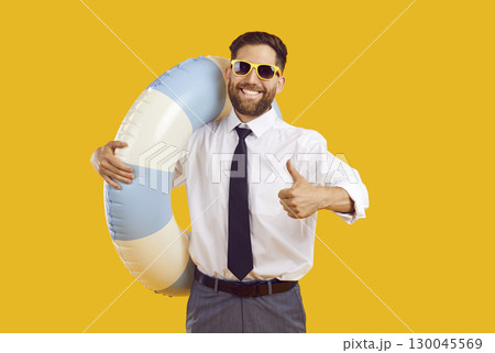 Man in office clothes showing thumb up sign on yellow background going on summer trip 130045569