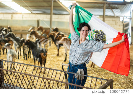 Hispanic female farmer posing in goat shed with Mexican flag Hispanic female farmer posing in goat shed with Mexican flag 130045774