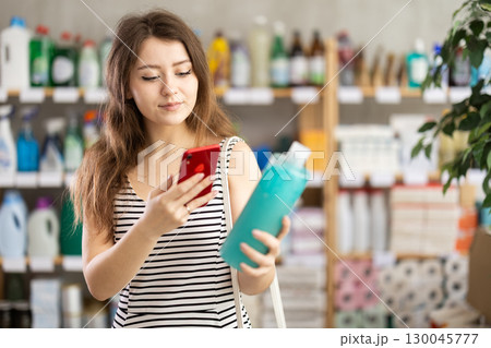 Woman scans shampoo barcode on her phone 130045777