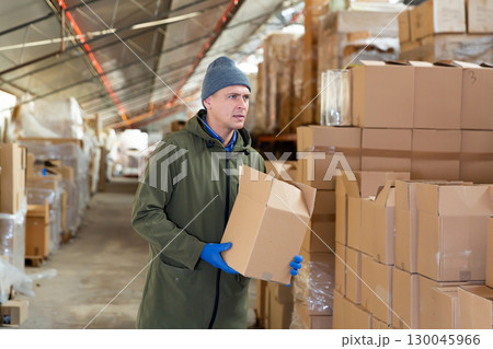 Man worker carrying cardboard box Man worker carrying cardboard box 130045966