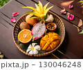 木製のお皿に盛り付けられたトロピカルフルーツです。 130046248