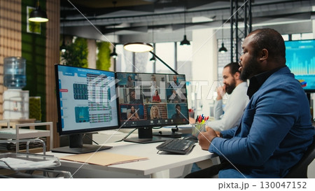 Black analyst meeting on online video call with associates to discuss insights and resource allocation, discussing about statistics with investors group via remote web chat. 130047152