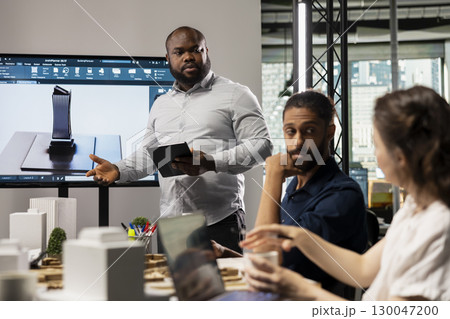 Group of diverse developers brainstorm innovative design ideas for construction and city planning, real estate experts meeting in a boardroom to ensure infrastructure growth project approval. 130047200