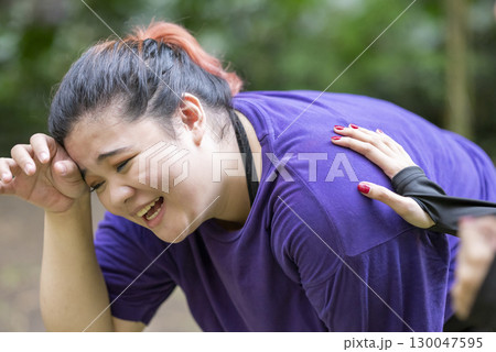 Indonesian southeast asian women in a sporty outfit encouraging her friend while running exercise in a public park outdoors. Concept of a Healthy active lifestyle Indonesian southeast asian women in a sporty outfit encouraging her friend while running exercise in a public park outdoors. Concept of a Healthy active lifestyle 130047595