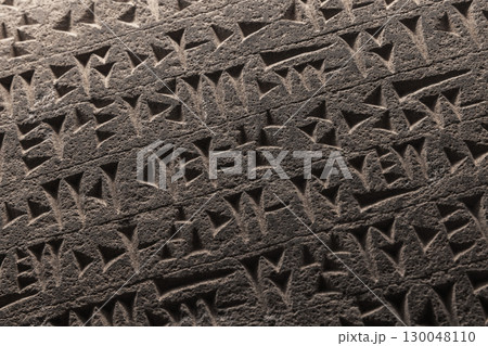 Ancient Sumerian cuneiform script etched into a stone 130048110