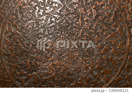 Decorative metal surface featuring precise handcrafted floral pattern Decorative metal surface featuring precise handcrafted floral pattern 130048121