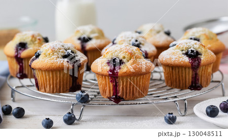Freshly baked blueberry muffins with powdered sugar on cooling rack, delicious homemade dessert concept 130048511