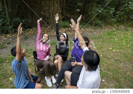 Indonesian southeast asian people in a sporty outfit, stacking hands together before practice exercise in a public park outdoors. Concept of a Healthy active lifestyle 130048809
