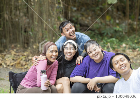 Indonesian southeast asian people in a sporty outfit taking a selfie together after practice exercise in a public park outdoors. Concept of a Healthy active lifestyle 130049036