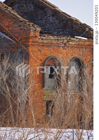 早春の北海道稚内市　残雪に囲まれたレンガ作りの旧秋田木材工場発電所跡 130049201