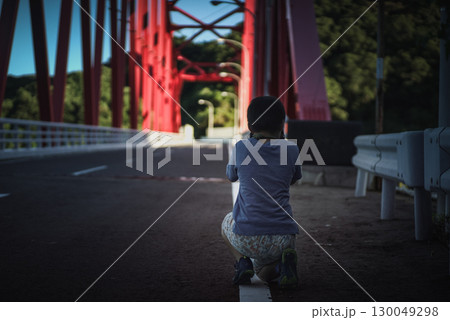 ＜素材＞朝の観光地でアーチ橋を撮る男の子 130049298