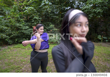 Indonesian southeast asian women in a sporty outfit practice exercise in a public park outdoors. Concept of a Healthy active lifestyle 130049408