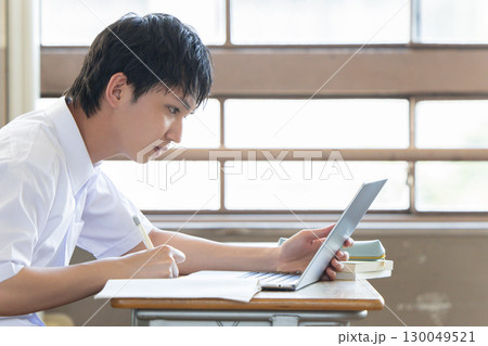パソコンを使って勉強する男子学生 130049521