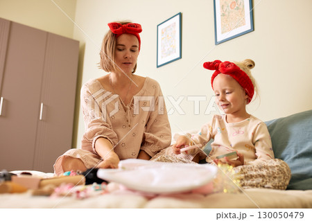 Mother and daughter bonding over crafts and playful activities 130050479