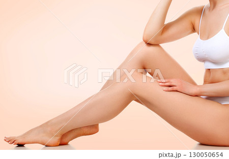 Pretty woman with slim beautiful body sitting against pastel background 130050654