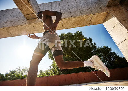 Athlete running outdoors under a sunny day with a bright urban backdrop Athlete running outdoors under a sunny day with a bright urban backdrop 130050792