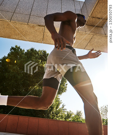 Athletic man running in a modern urban outdoor setting on a sunny day Athletic man running in a modern urban outdoor setting on a sunny day 130050793
