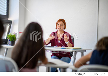 Teacher talking with children in primary class. Teacher talking with children in primary class. 130051333