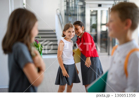 Schoolgirls teasing or gossiping about classmates. Schoolgirls teasing or gossiping about classmates. 130051350