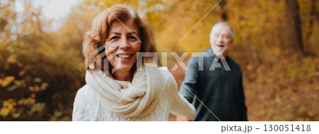 Happy elderly woman walking in forest with her husban, holding hands. Happy elderly woman walking in forest with her husban, holding hands. 130051418