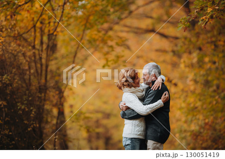 Older couple spending time outdoors in fall season. 130051419