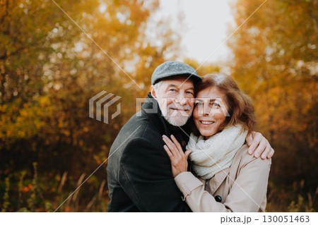 Older couple spending time outdoors in fall season. Older couple spending time outdoors in fall season. 130051463