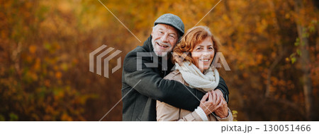 Older couple spending time outdoors in fall season. Older couple spending time outdoors in fall season. 130051466