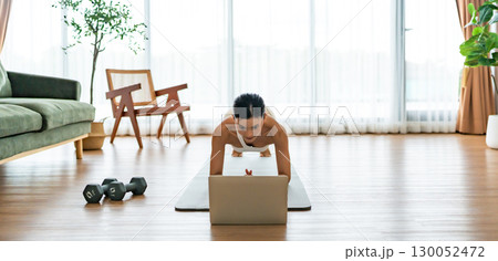 Young Asian woman in sportswear doing plank on training mat 130052472