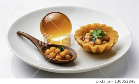 Unique dessert presentation with caviar-like spheres and pastry on a white plate 130052845