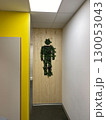 Man shape made from green plants on wooden wall in office hallway, viewed under ceiling lights 130053043
