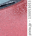 Frozen ice crystals on red car surface creating wintery abstract background 130053053