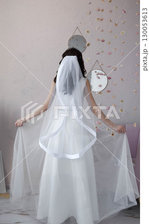 Bride in a white dress with a veil look from the back 130053613