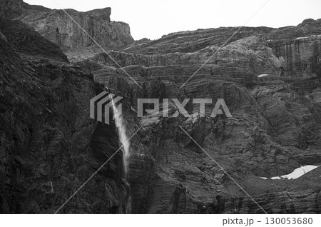 Flowing waterfall cascading down rugged cliffs of Cirque de Gavarnie in the Pyrenees, showcasing Flowing waterfall cascading down rugged cliffs of Cirque de Gavarnie in the Pyrenees, showcasing 130053680