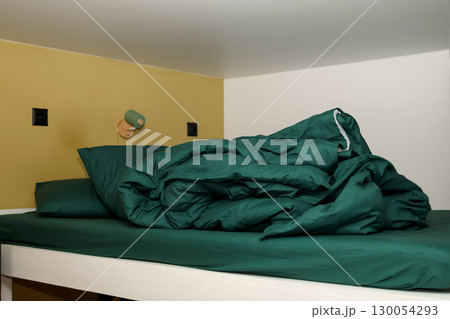a bunk bed with a green, crumpled, and messy blanket. a simple and a cozy design. messy bunk bed cozy room. crumpled green blanket lazy morning a bunk bed with a green, crumpled, and messy blanket. a simple and a cozy design. messy bunk bed cozy room. crumpled green blanket lazy morning 130054293
