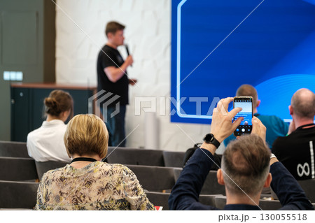 Speaker giving a presentation in a seminar with an engaged audience 130055518