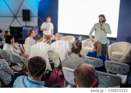 Group engaging in conference or workshop presentation in modern professional atmosphere 130055525