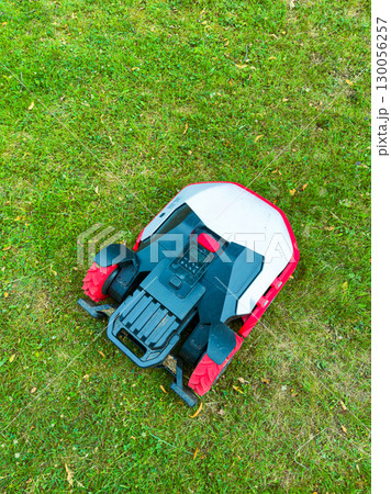 An Autonomous Robotic Lawn Mower gliding over lush green grass represents a fantastic smart gardening solution, making lawn care effortless and convenient, while maintaining a pristine outdoor space 130056257