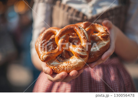 Traditional German pretzels in the hands of a girl in a national Bavarian dress. 130056478