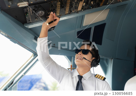 Portrait of a trained airplane captain in uniform preparing to fly in a simulator cockpit. Portrait of a trained airplane captain in uniform preparing to fly in a simulator cockpit. 130056685