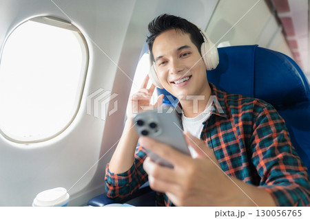 man, airplane, travel, enjoying comfortable flight while sitting in the airplane cabin. man, airplane, travel, enjoying comfortable flight while sitting in the airplane cabin. 130056765