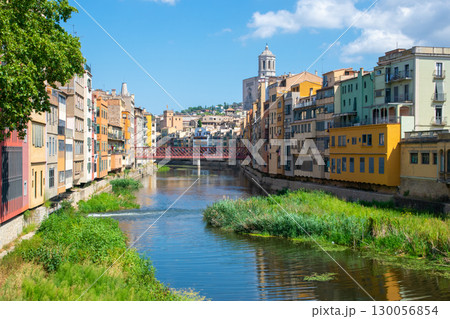 Beautiful street with historic houses, windows in the center of old town near little river. Spain. 130056854