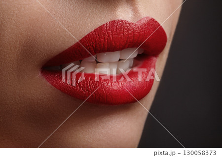 Part of female face. Macro photo of full female lips with ruby red lipstick makeup, sexually open mouth. Vamp Woman, Grunge or Halloween Style. Beauty fashion concept Part of female face. Macro photo of full female lips with ruby red lipstick makeup, sexually open mouth. Vamp Woman, Grunge or Halloween Style. Beauty fashion concept 130058373