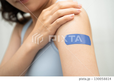 HPV, Human papillomavirus, Asian young woman receiving vaccine with blue bandage. 130058814