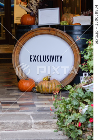 Equity, diversity, EXCLUSIVITY concept. Copy space. EXCLUSIVITY word written on Vibrant autumn display with colorful pumpkins and rustic decor 130059934