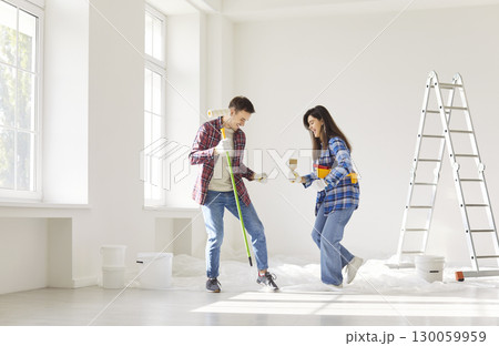 Smiling young family couple dancing and having fun during home renovation and decoration process. Smiling young family couple dancing and having fun during home renovation and decoration process. 130059959