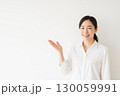 案内をする笑顔の若い女性 130059991